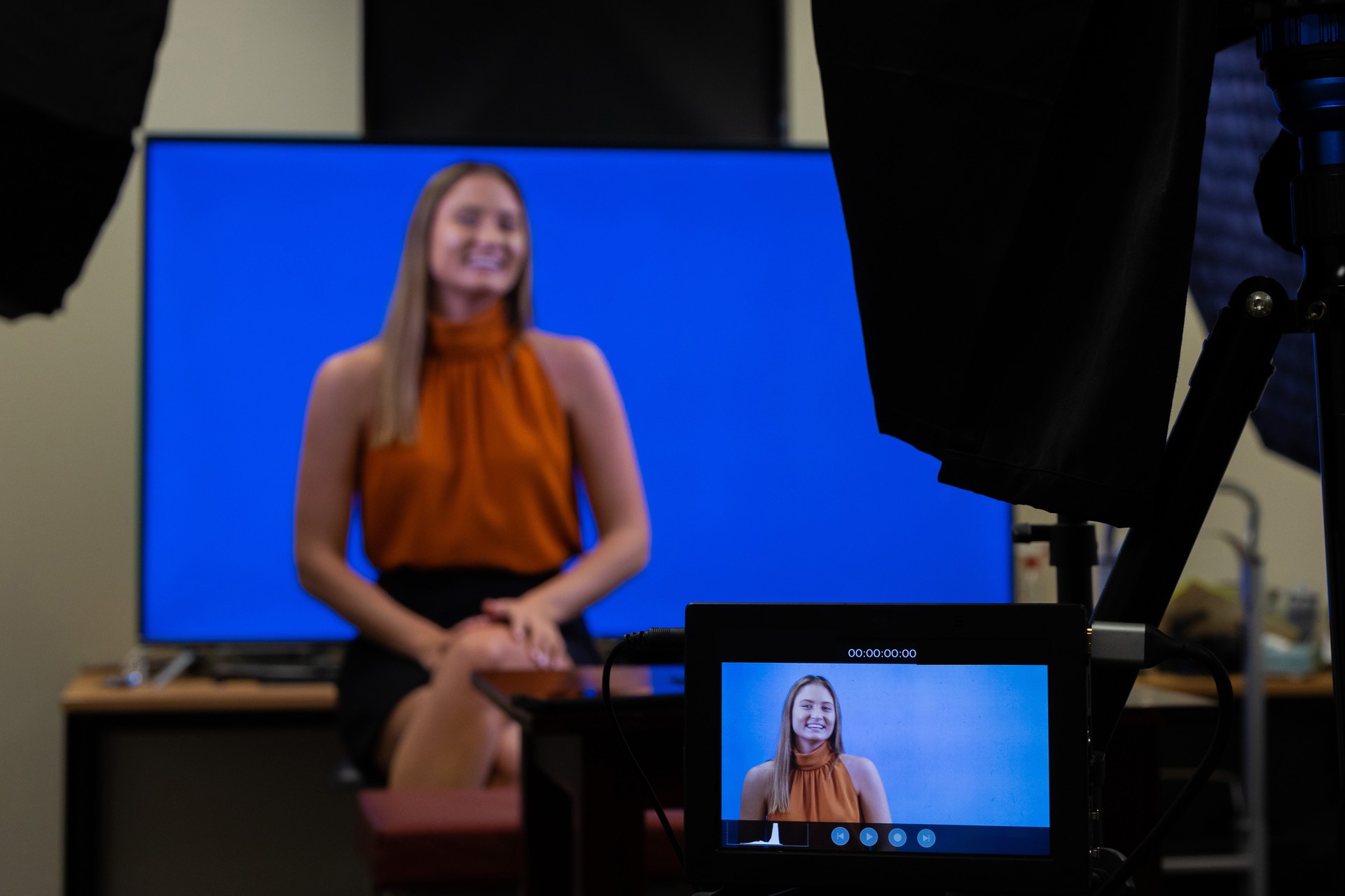 Female behind the scenes in recording studio with camera equipment